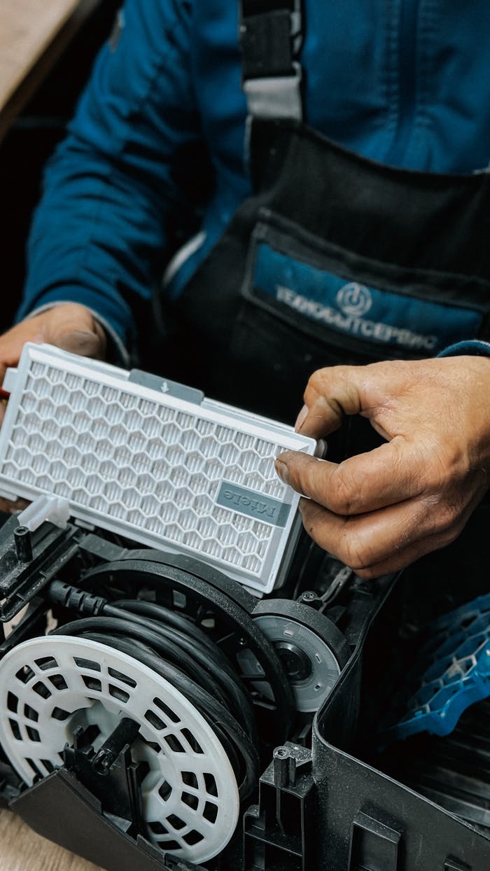 journey Close-up of a technician handling an air filter during a vacuum cleaner repair.